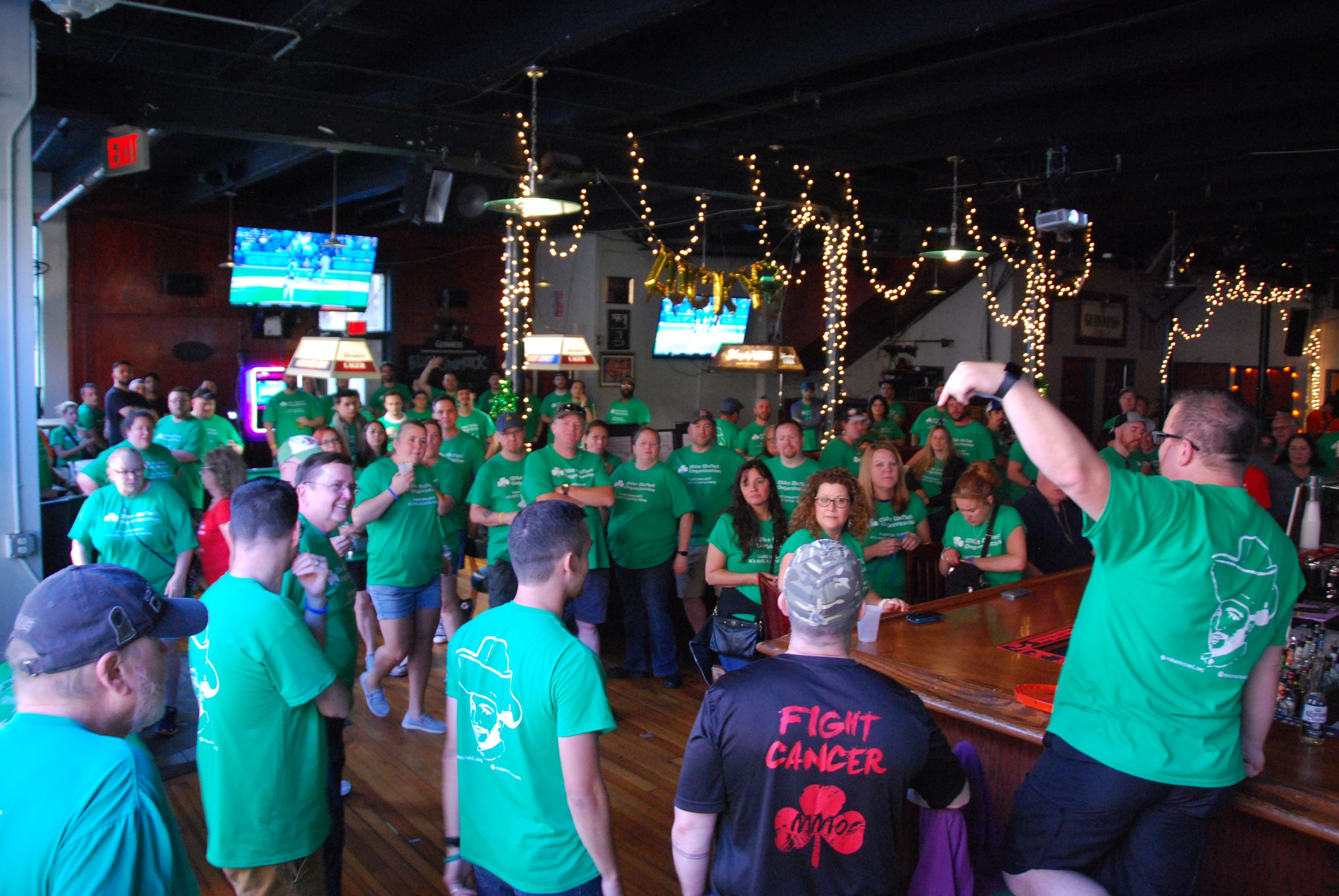 A bar full of crawlers in green shirts gathered for the kickoff at a past Crawl for a Cure